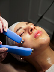 Naklejka premium Beautician performs the Microstorums procedure to restore facial cells