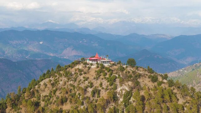 Aerial drone shot of a hindu temple on top of the mountain in uttarakhand