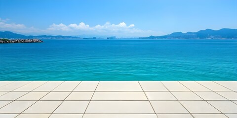 Fototapeta premium A clear blue ocean extends to distant mountains under a bright sky, with a tiled surface in the foreground. Concept Serene Ocean View, Distant Mountains, Bright Sky, Tiled Foreground