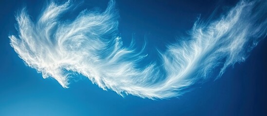 Obraz premium White feather-like cloud formation against a vibrant blue sky.
