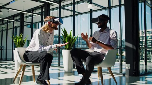 Two individuals engage in a virtual reality session in a modern office setting with large windows and plenty of natural light