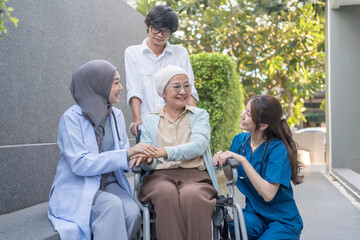 senior woman cancer patient on wheelchair,family,health care workers supporting,talking and...