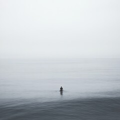 Solitary Figure Standing in Tranquil Waters Under a Misty Sky