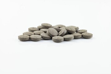 Close-up of gray tablets on white