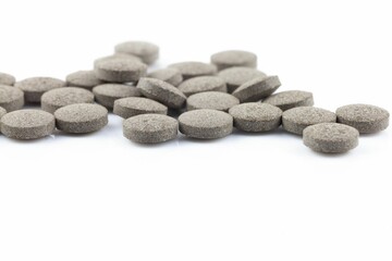 Scattered gray pills on white background