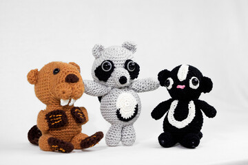 Drei gehäkelte Stofftiere: Biber, Stinktier und Waschbär