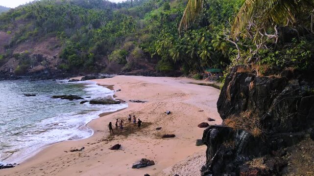 Aerial drone shot of a group of friends playing at the beach