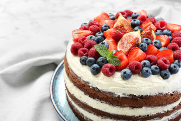 Delicious chocolate sponge cake with berries on white table, closeup