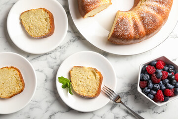 Freshly baked sponge cake, mint and berries on white marble table, top view