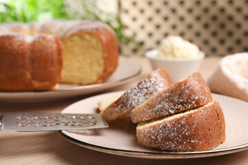 Pieces of freshly baked sponge cake, server and ice cream on wooden table, closeup