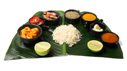 Cut banana leaf with different food, spices and sauce isolated on white. Healthy eco serving