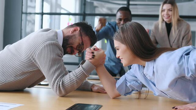 Fun times. Office workers are doing arm wrestling.