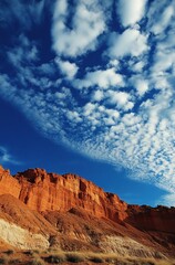 Fototapeta premium A mountain range with a blue sky and clouds