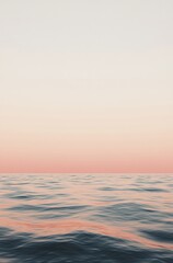 Obraz premium A calm ocean with a pink sky in the background