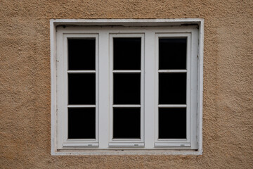 White old frame with glass window on a beige stone wall, no person, 