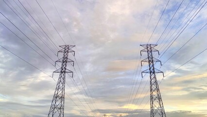 Twin Electrical Power Line Towers Against Overcast evening Sky Background