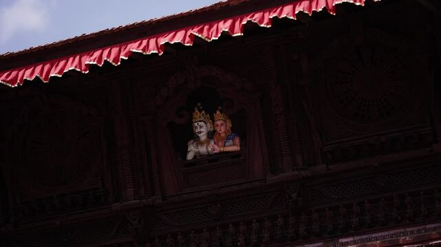 Statue of Radha Krishna carved on wood looking from the window at Kathmandu Durbar Square
