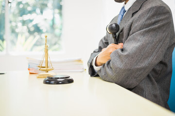 Male lawyer diligently examines documents placed on his desk, demonstrating his professionalism and dedication to finding legal truth, analyzing ideas, and pursuing justice with relentless focus.