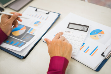 A focused man works diligently in his office, reviewing numerous accounting documents on his desk....
