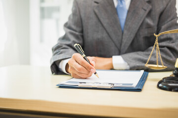 Male lawyer diligently examines documents placed on his desk, demonstrating his professionalism and dedication to finding legal truth, analyzing ideas, and pursuing justice with relentless focus.