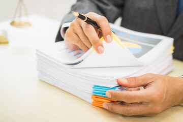 Male lawyer diligently examines documents placed on his desk, demonstrating his professionalism and dedication to finding legal truth, analyzing ideas, and pursuing justice with relentless focus.