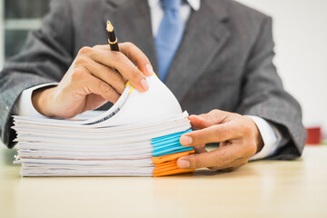 Male lawyer diligently examines documents placed on his desk, demonstrating his professionalism and dedication to finding legal truth, analyzing ideas, and pursuing justice with relentless focus.