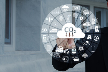 Man's finger points to reduce CO2 and icons on natural background.