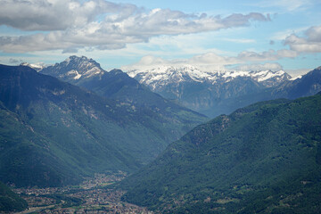 Naklejka premium Snow covered Swiss Alps with Bellinzona Town in the valley and cloud covered blue sky, Switzerland