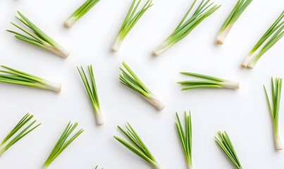 Flat lay of fresh green onions on white background.
