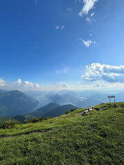 View of Monte Boglia mountaintop and Lugano with Lugano lake in the background on a beautiful summer day with blue sky and sun shining, Switzerland