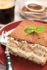 Delicious tiramisu with mint on table, closeup