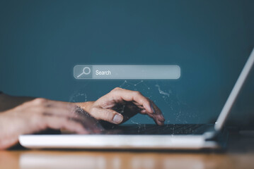 Hands typing on a laptop keyboard with a glowing search bar overlay, symbolizing online searching and internet research.