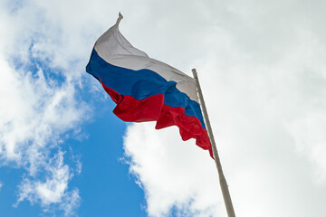 Russian flag flying on a flagpole in a strong wind. symbol of patriotism. Tula, Russia