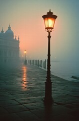 A street lamp is lit up in the fog