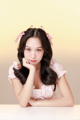 Fototapeta premium Young Asian smiling woman braces teeth wearing a light pastel dress and ribbons, on isolated a soft gradient background.