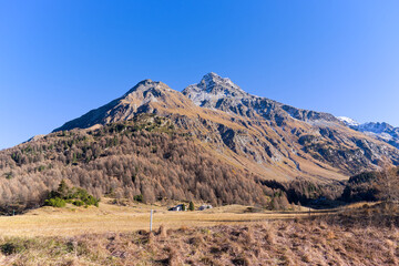 Mountain panorama in the Swiss Alps seen from mountain village of Maloja on a sunny autumn day. Photo taken November 15th, 2024, Maloja Bregaglia, Switzerland.