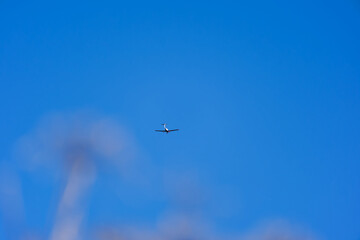 Propeller airplane up in the sky in Swiss Alps seen from mountain village of Maloja on a sunny autumn day. Photo taken November 15th, 2024, Maloja Bregaglia, Switzerland.