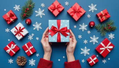 Fototapeta premium A person is holding a blue box with a red bow on it