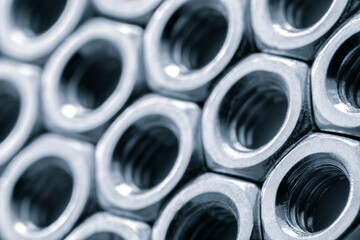 Metal nuts in a row background. Chromed screw nuts. Steel nuts pattern. Tools for work.
