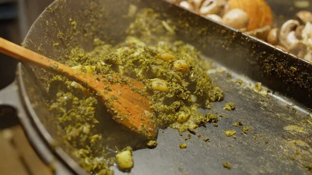 Slow Motion of cooking and making kale next to cham in a very big pan with onions and potatos. Making kale with potatoes and onions in a very big pan