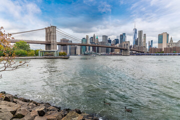 A view across the East river towards the Brooklyn bridge and Manhattan in New York, in the fall