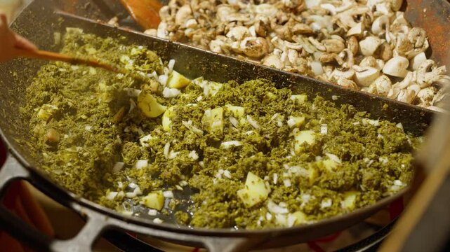 Slow Motion of cooking and making kale next to cham in a very big pan with onions and potatos. Making kale with potatoes and onions in a very big pan