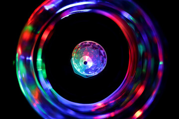 Close up of the colorful party light surrounded by the vortex of blurry colors