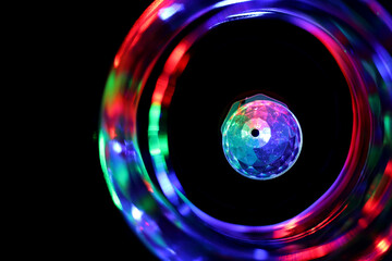 Close up of the colorful party light surrounded by the vortex of blurry colors