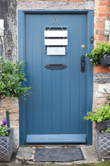 Blue Cottagecore vintage style front door to old house decorated to feel welcoming and homely