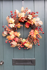 Old wooden door cottage style front door with autumn coloured foliage wreath