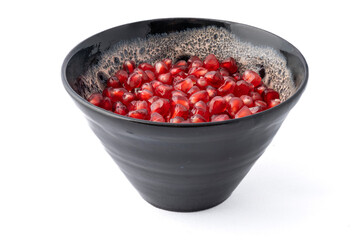 Gennevilliers, France - 01 02 2024: Close up of a gray and white clay bowl filled with red triangular pomegranate seeds on a white background.