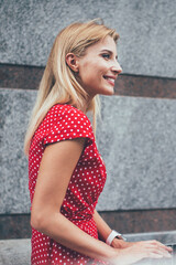 Side view of sincerely female digital nomad working remotely at urbanity enjoying freelance...