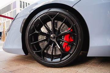 Close-up sports car red brake caliper with tire and black rim