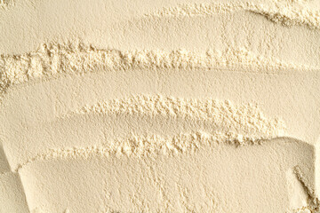 Beige background made of whey protein powder